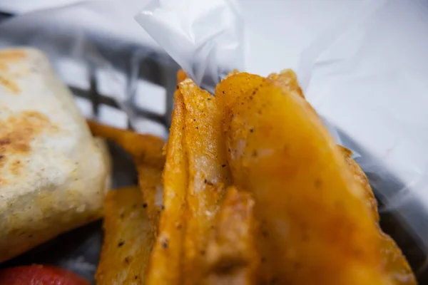 Cuñas de patata y burritos en una canasta de plástico —  Fotos de Stock