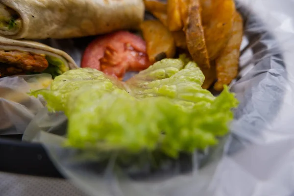 Pikantní vepřové burritos a salát v plastovém koši — Stock fotografie