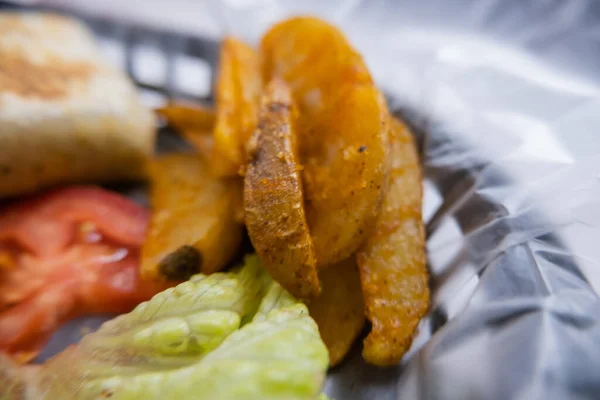 Spicy pork burritos and lettuce in a plastic basket — Stock Photo, Image