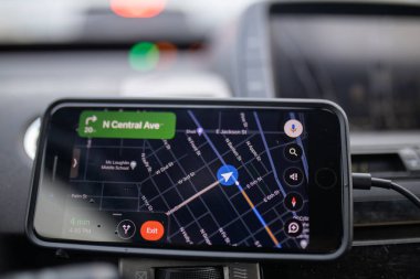 Cep telefonunda gösterilen GPS bir arabanın ön panelinin üzerinde