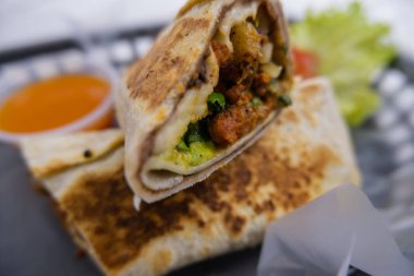 Plastik sepette baharatlı domuz burrito ve marul.