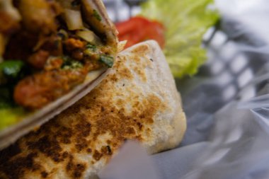Plastik sepette baharatlı domuz burrito ve marul.