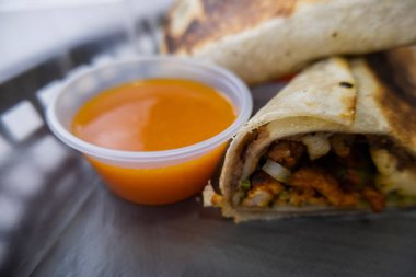 Plastik sepette baharatlı domuz burrito ve marul.