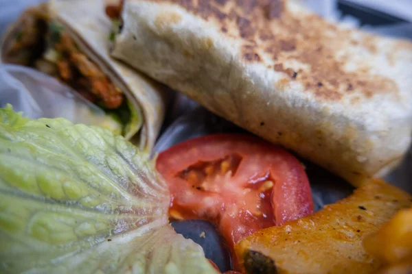 Spicy pork burritos and lettuce in a plastic basket — Stock Photo, Image