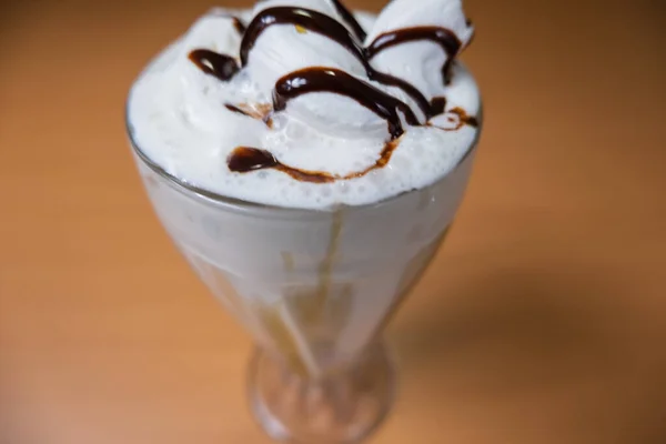 Milkshake de baunilha com xarope de chocolate em uma mesa — Fotografia de Stock