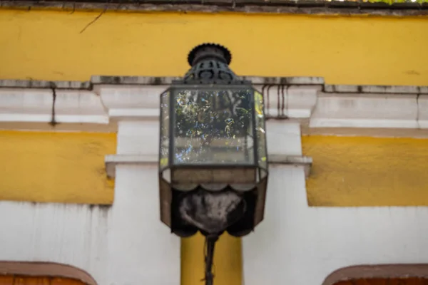Lanterna clássica pendurada em um antigo edifício amarelo — Fotografia de Stock