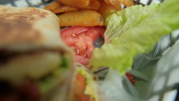 Würzige Schweineburritos und Salat in einem Plastikkorb — Stockvideo