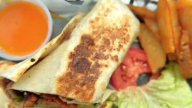 Plastik sepette baharatlı domuz burrito ve marul.