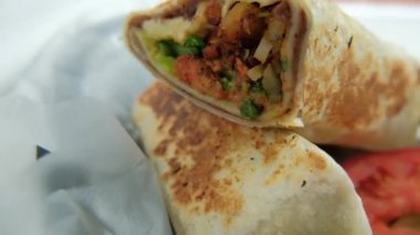 Plastik sepette baharatlı domuz burrito ve marul.