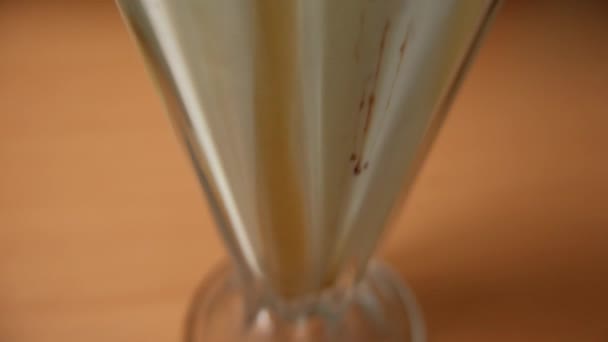 Vanilla milkshake dengan sirup coklat di atas meja — Stok Video