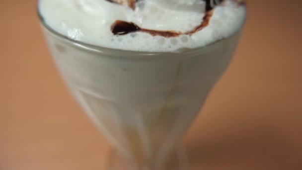 Milkshake de baunilha com xarope de chocolate em uma mesa — Vídeo de Stock