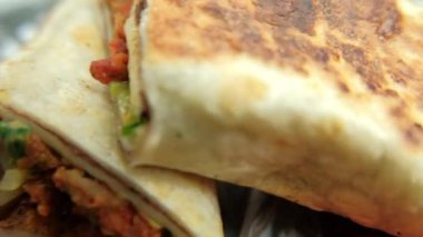 Plastik sepette baharatlı domuz burrito ve marul.