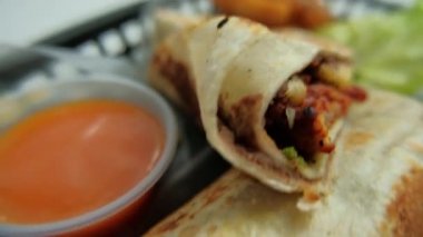 Plastik sepette baharatlı domuz burrito ve marul.