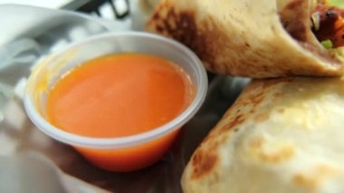 Plastik sepette baharatlı domuz burrito ve marul.