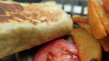 Plastik sepette baharatlı domuz burrito ve marul.