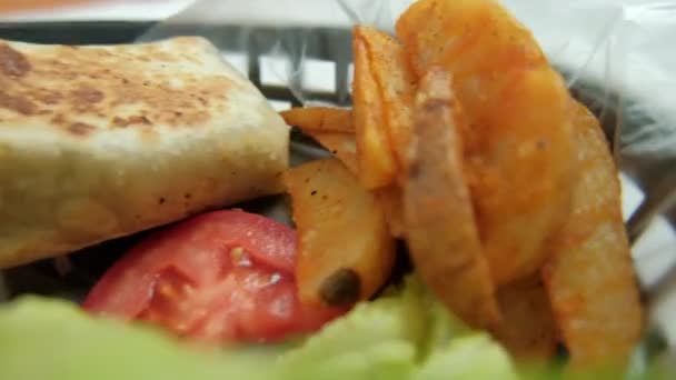 Пряные буррито со свининой и салатом в пластиковой корзине — стоковое видео
