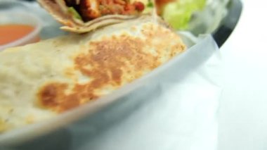 Plastik sepette baharatlı domuz burrito ve marul.