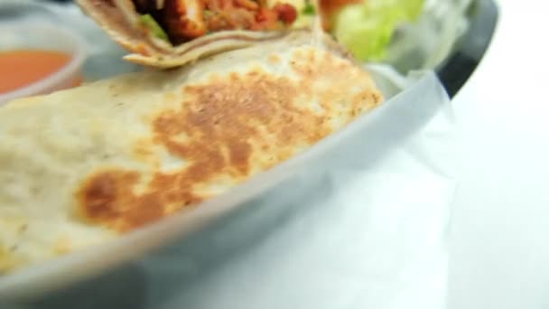 Würzige Schweineburritos und Salat in einem Plastikkorb — Stockvideo
