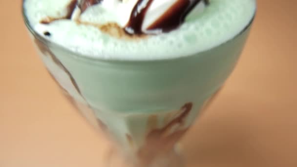 Mléčný koktejl s kousky čokolády a sirupem na stole — Stock video