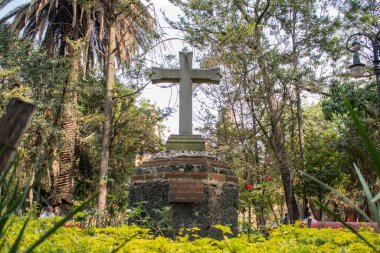Coyoacan 'dan bir parkın ortasındaki taş haç.