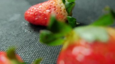 Masa örtüsü olan bir masada izole edilmiş çilekler.