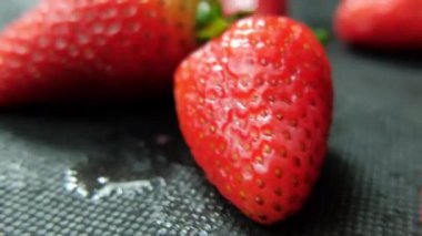 Masa örtüsü olan bir masada izole edilmiş çilekler.