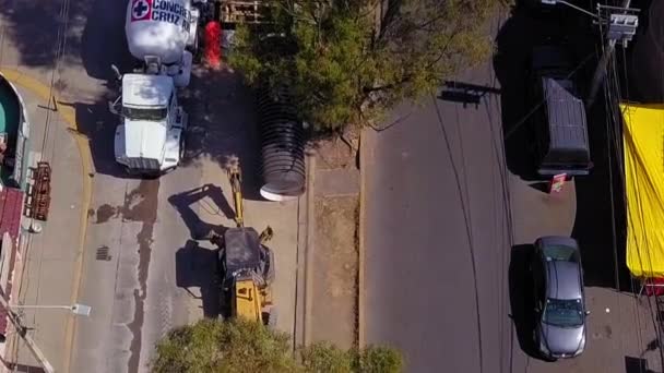 Vista aérea de una excavadora en una calle en construcción — Vídeo de stock
