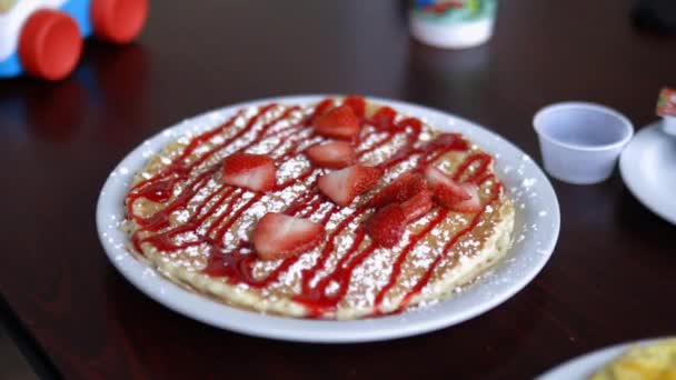 Crêpe aux tranches de fraise et sirop sur une assiette blanche — Video