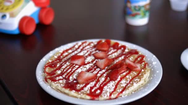 Pancake dengan irisan stroberi dan sirup di piring putih — Stok Video