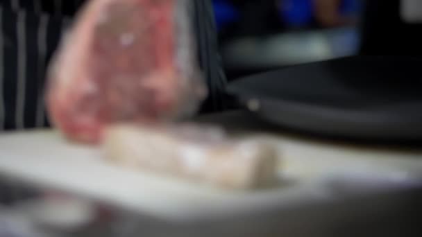 Männliche Hände packen ein saftig aussehendes Stück Fleisch vorsichtig aus — Stockvideo
