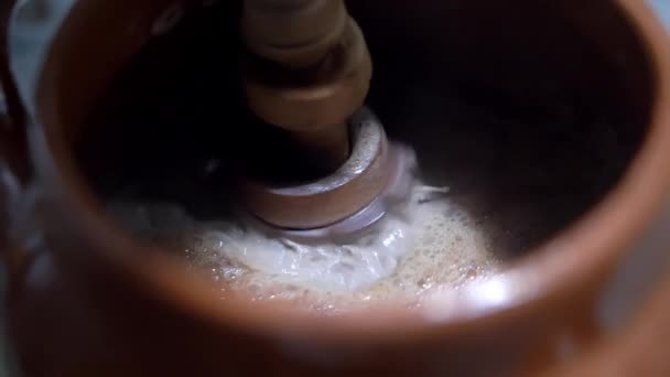 Agitar el cacao caliente en una olla de barro con molinillo mexicano — Vídeos de Stock