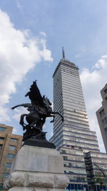 Mavi gökyüzünün altındaki Latin Amerika Kulesi ve Pegasus heykelinin alçak açılı görüntüsü