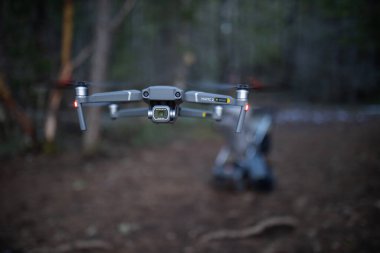 İnsansız hava aracı ormanın ortasında alçaktan uçuyor.