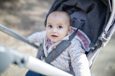 Bebek arabasındaki sevimli ve meraklı bebek. Geçmişi bulanık.
