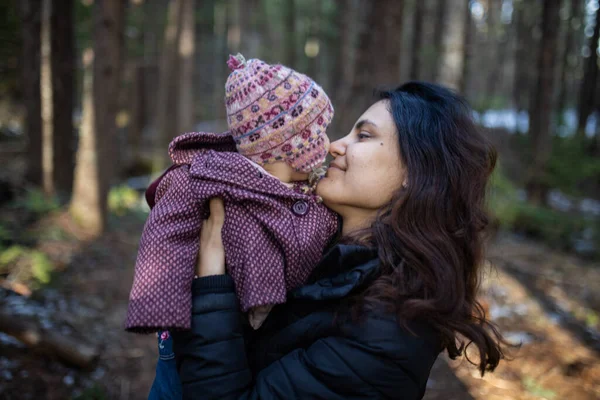 Mujer feliz abrazando a su adorable bebé en el bosque — Foto de Stock