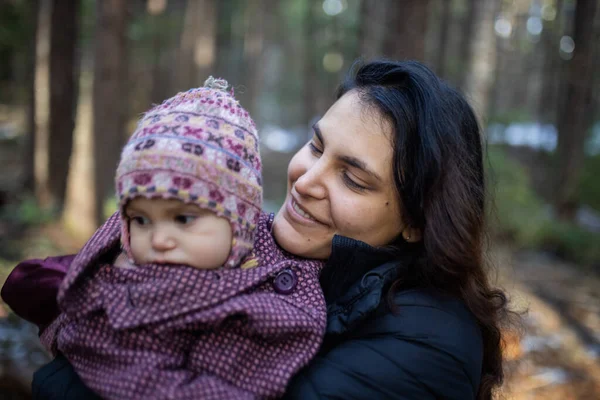 Donna felice che tiene il suo adorabile bambino nella foresta — Foto Stock