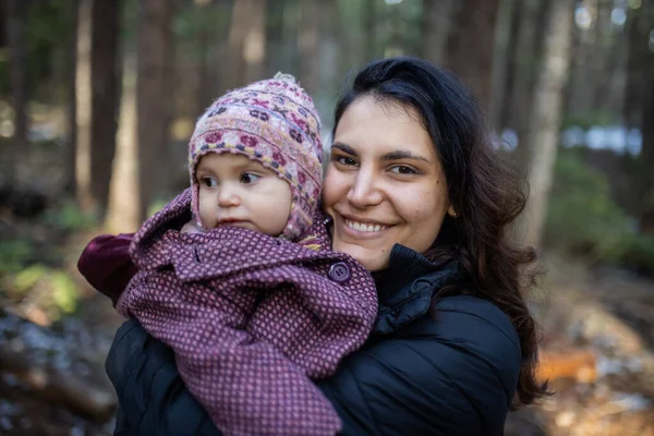 Donna felice che abbraccia il suo adorabile bambino nella foresta — Foto Stock