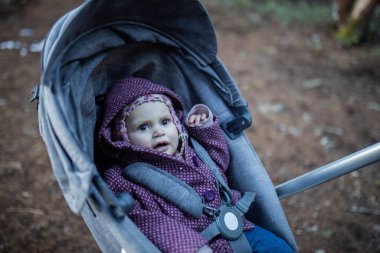 Bebek arabasındaki sevimli ve korkmuş görünümlü bebek. Geçmişi bulanık.