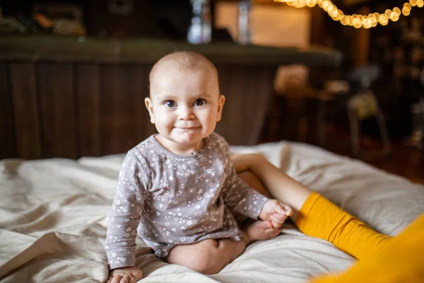 Adorável e feliz bebê sentado em uma cama — Fotografia de Stock