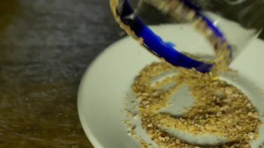 Erkek eller cam bardağın kenarına acı biber tozu sürüyor.