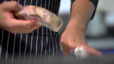 Erkek eli dikkatle sulu bir et parçasını açıyor.