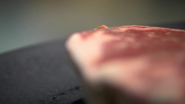 Siyah tabakta çiğ bir et parçasına yakın çekim — Stok video
