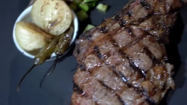 Мясо на гриле, салат, жареный лук и перец чили на тарелке — стоковое видео