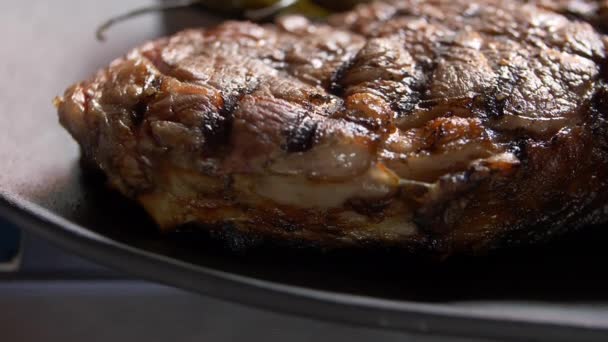 Großaufnahme von gegrilltem Fleisch auf einem schwarzen Teller — Stockvideo