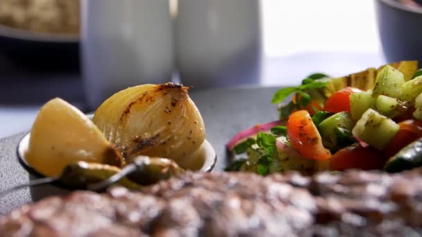 Grilované maso, salát, pečená cibule a chilli papričky na talíři — Stock video