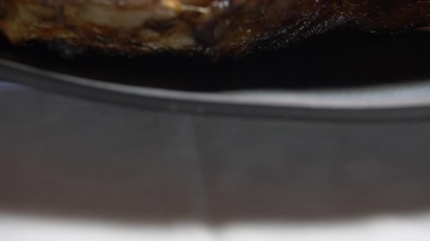 Крупный план жареного мяса на черной тарелке — стоковое видео