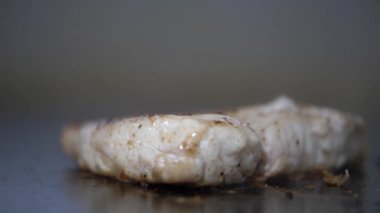 Bulanık arka planda ızgarada sulu bir biftek kızartıyorum.