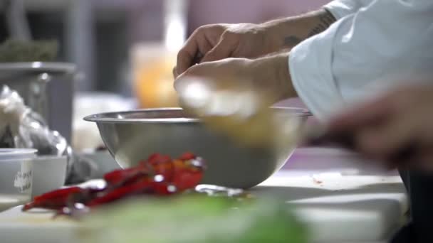 Hand mit Spachtel und Hühnerscheiben auf Salat — Stockvideo