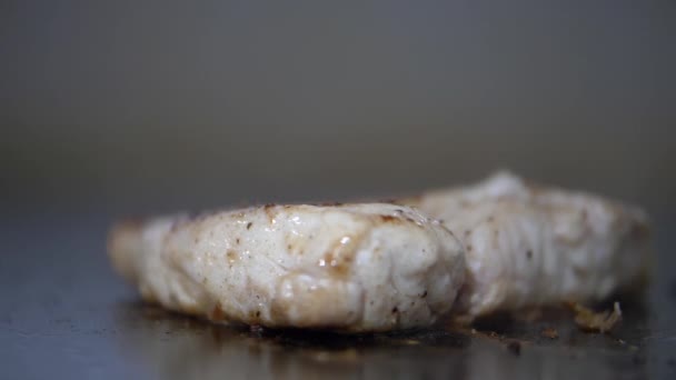 Frying juicy-looking steak on a griddle with blurry background — Stock Video