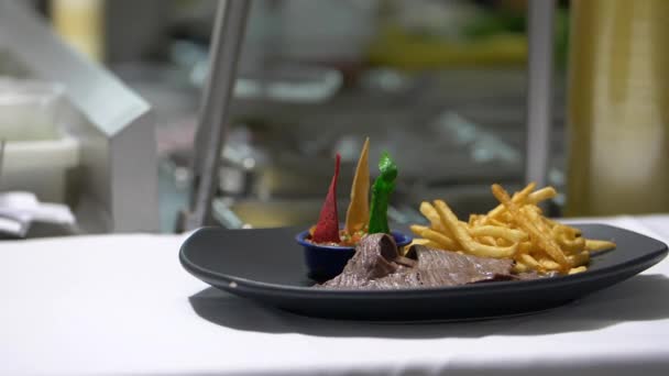 カラフルなトルティーヤスライス、フライドポテト、黒プレート上の薄いステーキ — ストック動画